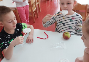 dzieci jedzą bezy i jabłuszka